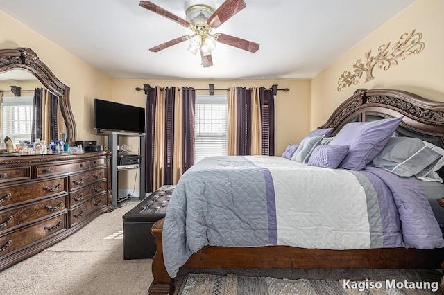 bedroom featuring light colored carpet, ceiling fan, and multiple windows
