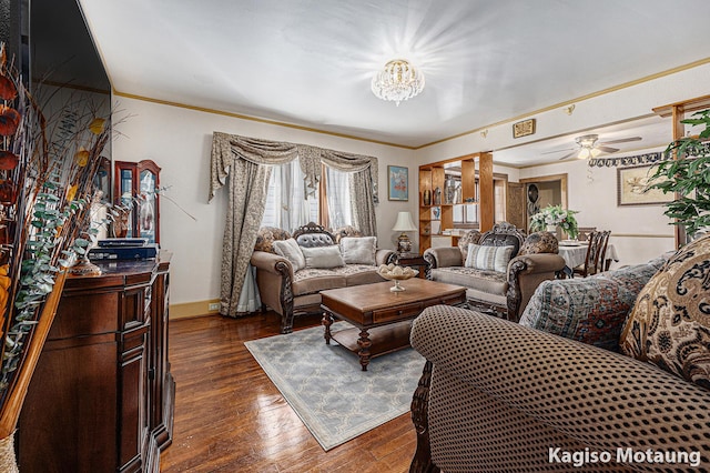 living area featuring baseboards, a ceiling fan, dark wood-style flooring, and crown molding