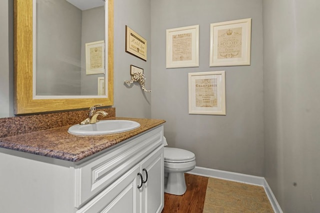 1293 Huntcliff, Milford, MI 48380 - half bath featuring vanity, toilet, wood finished floors, and baseboards