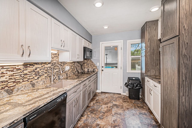 604 E N St, Owosso, MI 48867 - kitchen with black appliances, a sink, stone finish floors, tasteful backsplash, and light stone counters