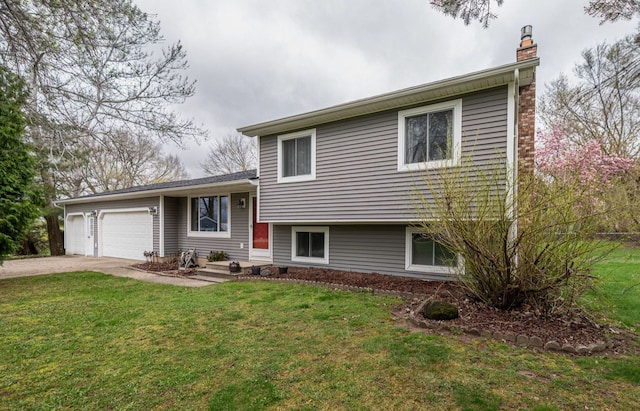 split level home featuring a chimney, a front yard, a garage, and concrete driveway