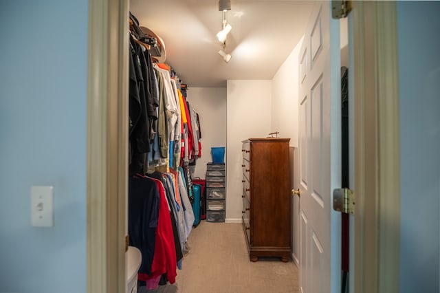 walk in closet with light colored carpet