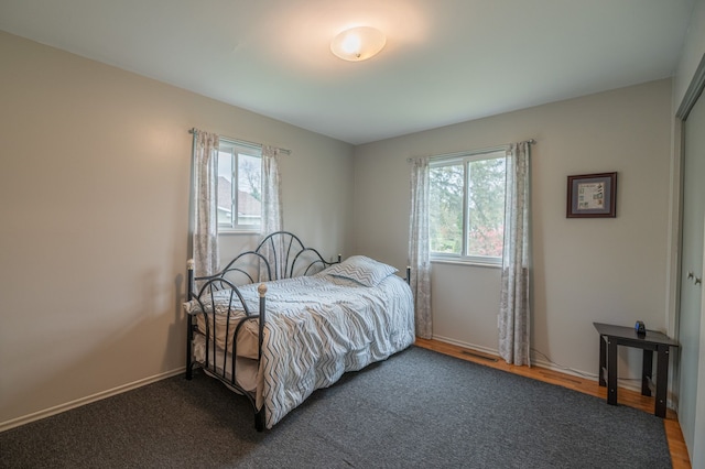 bedroom with multiple windows, visible vents, and baseboards