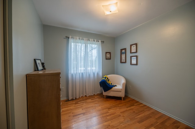 sitting room with baseboards and light wood finished floors