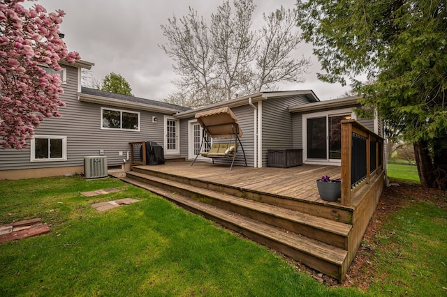 back of property featuring a lawn, a deck, and cooling unit
