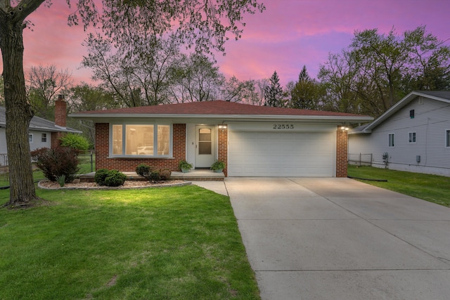 single story home featuring brick siding, a garage, a lawn, and driveway