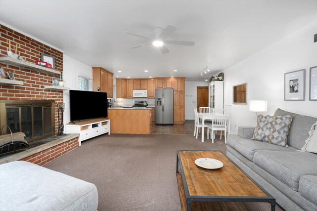 carpeted living room featuring ceiling fan and a brick fireplace