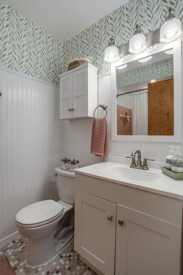bathroom featuring wainscoting, vanity, toilet, wallpapered walls, and a shower with shower curtain