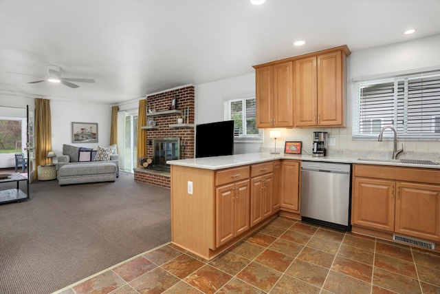 kitchen with visible vents, dishwasher, a sink, light countertops, and a peninsula