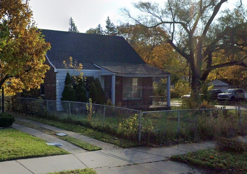 view of front of home with a fenced front yard and roof with shingles
