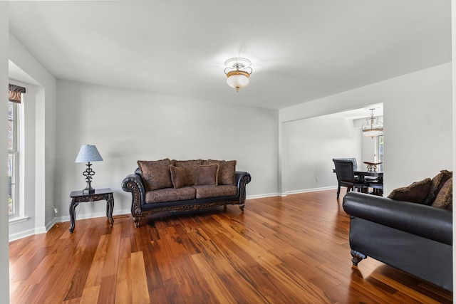 living room with a notable chandelier, wood finished floors, and a wealth of natural light