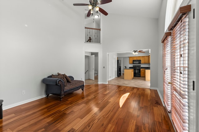 entryway featuring a ceiling fan, high vaulted ceiling, and baseboards