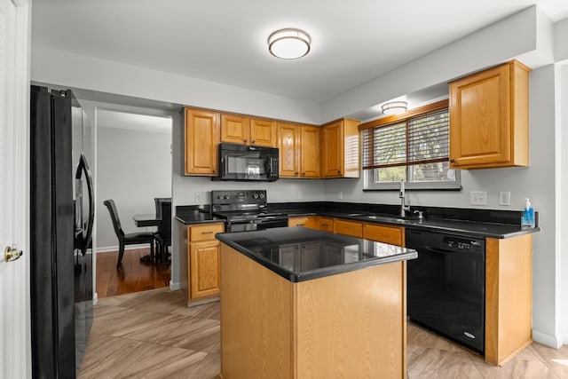 kitchen with a kitchen island, baseboards, a sink, and black appliances