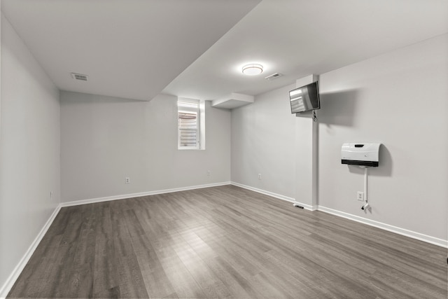 below grade area featuring visible vents, dark wood finished floors, and baseboards