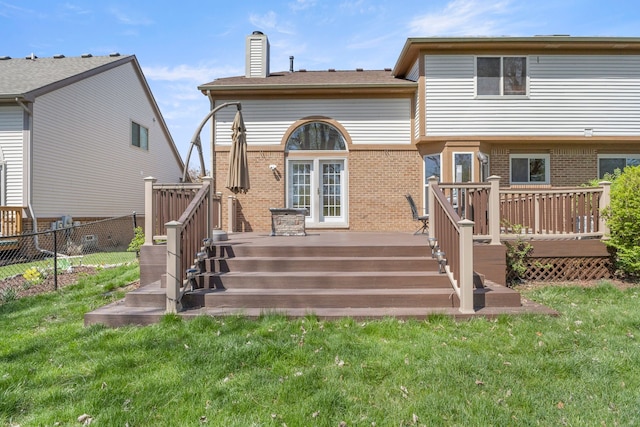 back of house featuring brick siding, fence, a yard, and a wooden deck