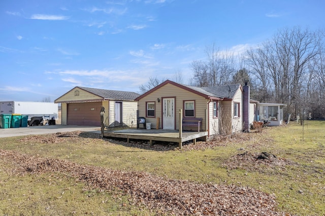 view of front of property with a garage, a wooden deck, a chimney, an outdoor structure, and driveway