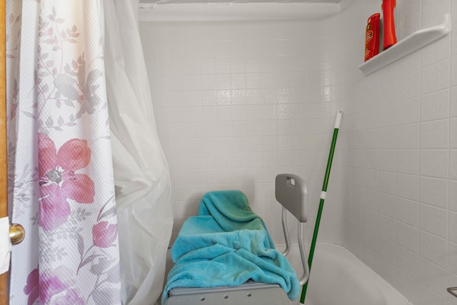 bathroom with curtained shower and a bath