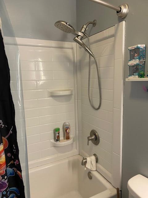 full bath with shower / bath combo and toilet