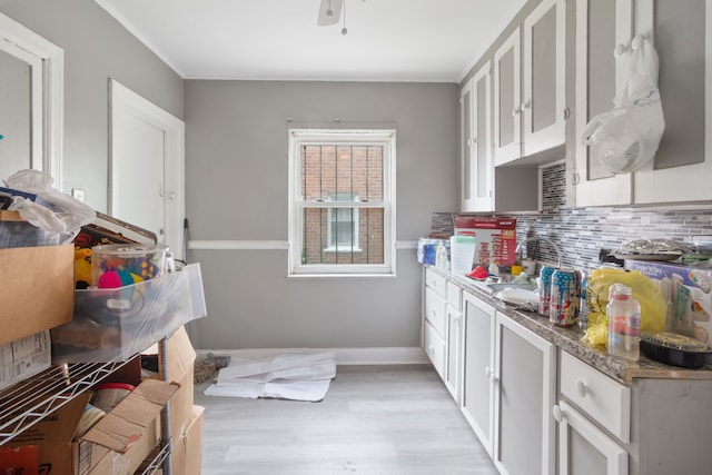 8690 Elmira St, Detroit, MI 48204 - kitchen featuring backsplash, white cabinets, light wood-style flooring, crown molding, and a sink