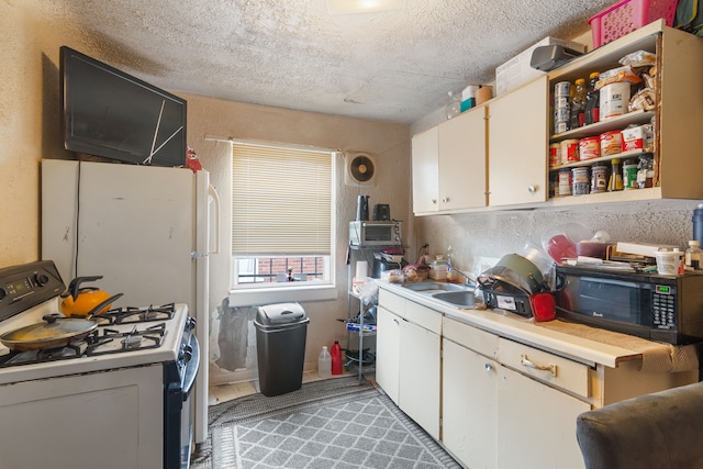 8690 Elmira St, Detroit, MI 48204 - kitchen with gas range, black microwave, light countertops, white cabinetry, and a textured ceiling