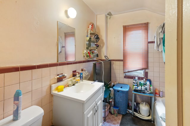 8690 Elmira St, Detroit, MI 48204 - bathroom featuring tile walls, vanity, toilet, and a wainscoted wall