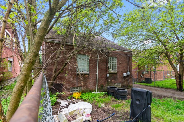 8690 Elmira St, Detroit, MI 48204 - view of home's exterior with brick siding, fence, and central AC