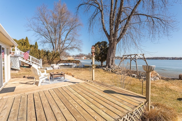 wooden terrace featuring a water view and stairway