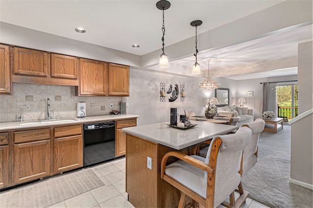 kitchen featuring black dishwasher, brown cabinetry, a sink, and light countertops