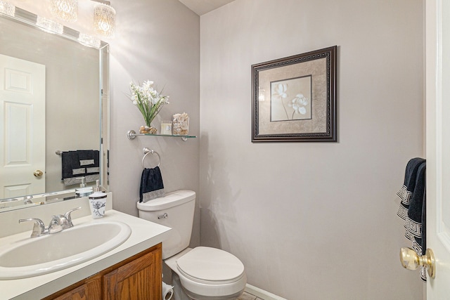 bathroom with vanity, baseboards, and toilet
