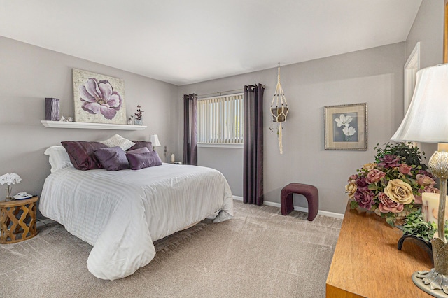 bedroom with baseboards and light colored carpet