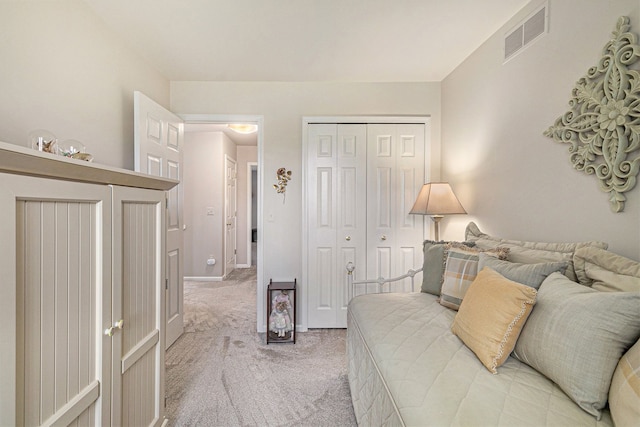 carpeted bedroom featuring visible vents and a closet