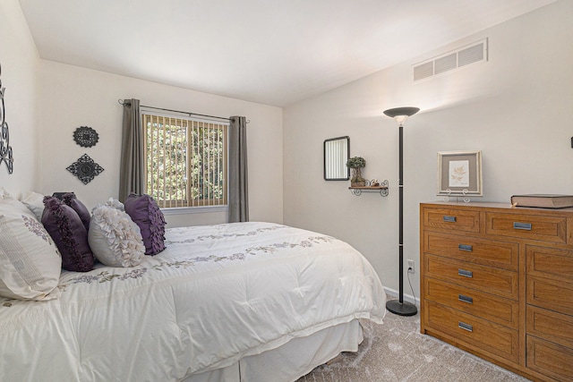 bedroom featuring baseboards, light carpet, and visible vents