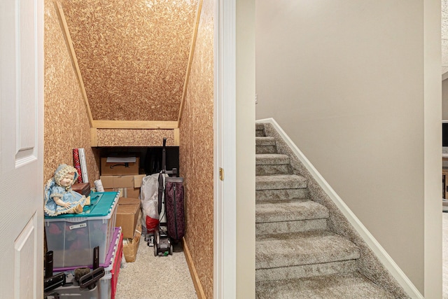staircase with baseboards and carpet flooring