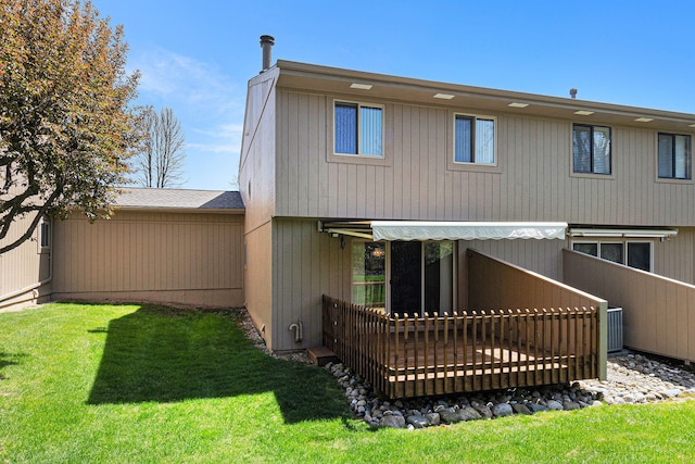 rear view of property featuring a shingled roof and a yard