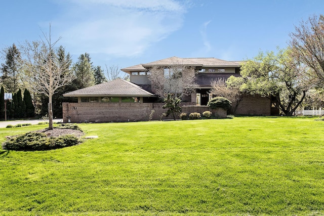 prairie-style house featuring brick siding and a front lawn