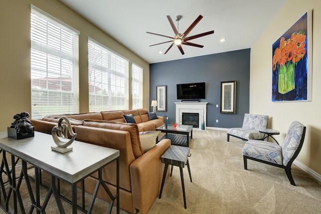 carpeted living area featuring a ceiling fan, baseboards, a glass covered fireplace, and recessed lighting
