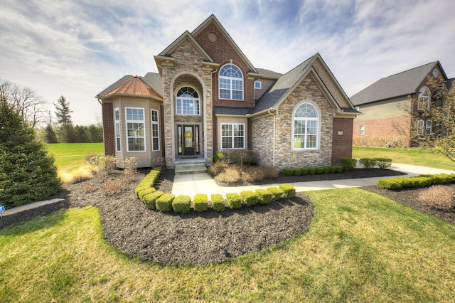 view of front of house featuring a standing seam roof, a front lawn, and stone siding