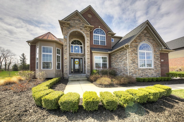 view of front of home with a standing seam roof and stone siding