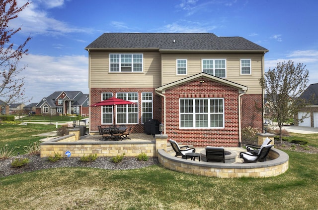 back of house with a patio, a lawn, and brick siding
