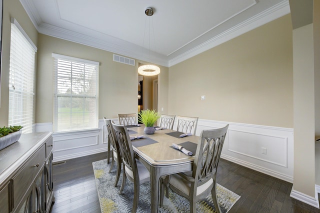 dining room featuring crown molding, visible vents, a wainscoted wall, and dark wood-type flooring