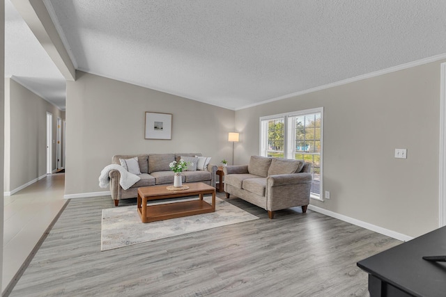 living room with a textured ceiling, ornamental molding, baseboards, and light wood finished floors