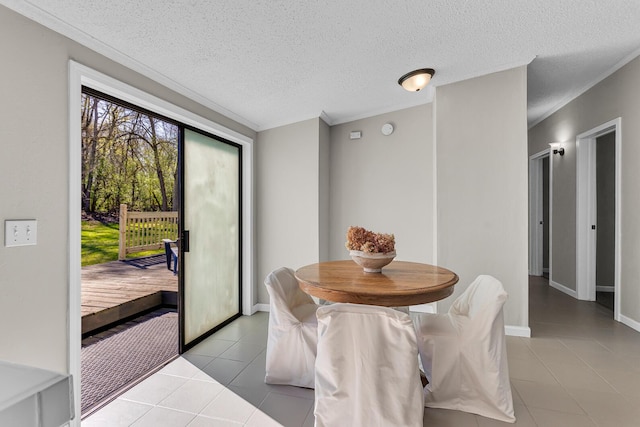 dining space featuring crown molding, a textured ceiling, and light tile patterned floors