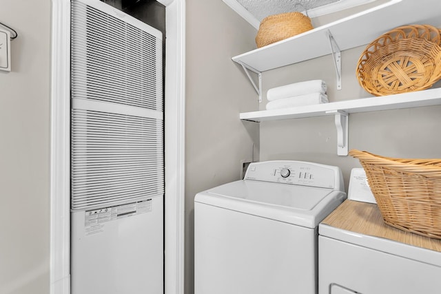 washroom with crown molding, laundry area, washer and clothes dryer, and a heating unit