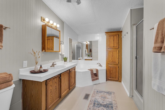 bathroom featuring a garden tub, a textured ceiling, visible vents, a shower stall, and toilet