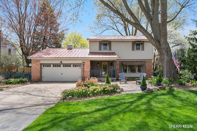 traditional-style house with a garage, fence, a front yard, and brick siding