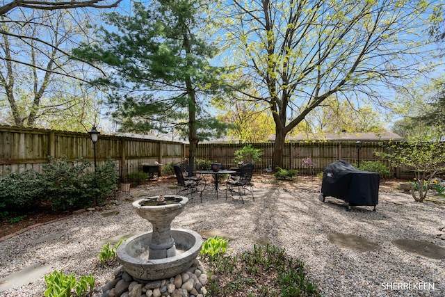 view of yard featuring a fenced backyard, a patio, and outdoor dining area
