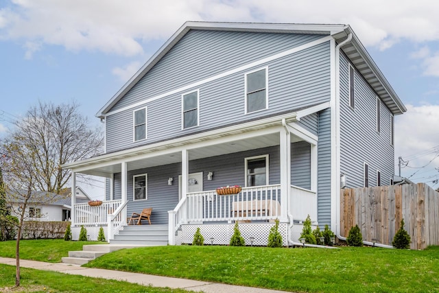 view of front of house with covered porch, fence, and a front yard