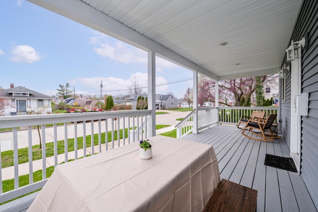 wooden terrace featuring covered porch and a residential view
