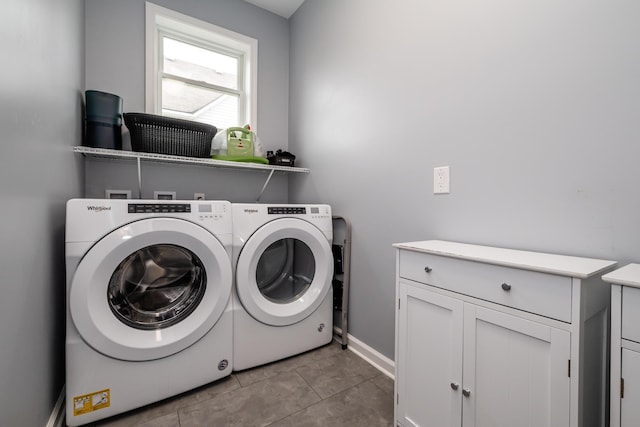 laundry area featuring washer and dryer, light tile patterned floors, and cabinet space