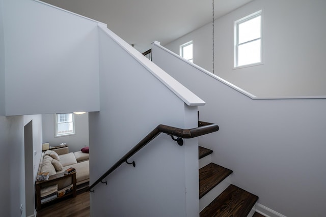 stairway with baseboards and wood finished floors